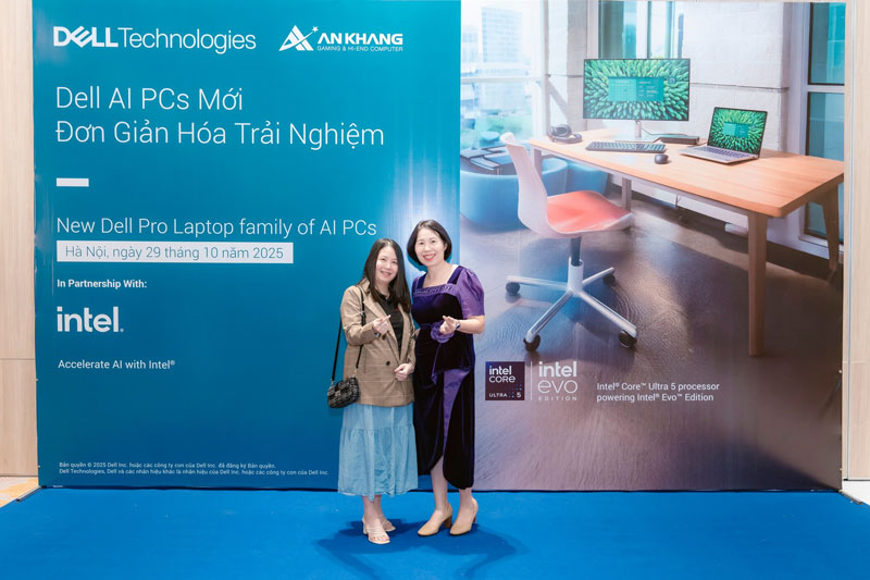 Nhân viên An Khang chụp ảnh lưu niệm cùng Quý khách hàng nữ tại khu vực backdrop chính của sự kiện, thể hiện sự kết nối thân thiện.